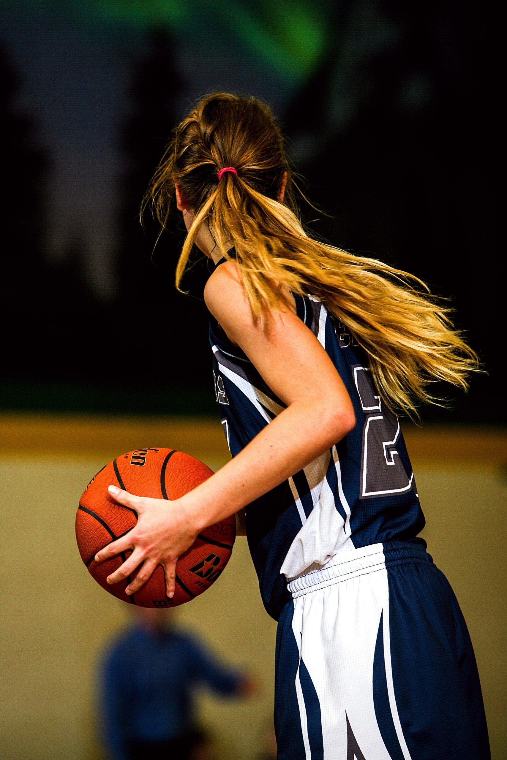 woman-in-blue-and-white-basketball-jersey-holding-brown-159607